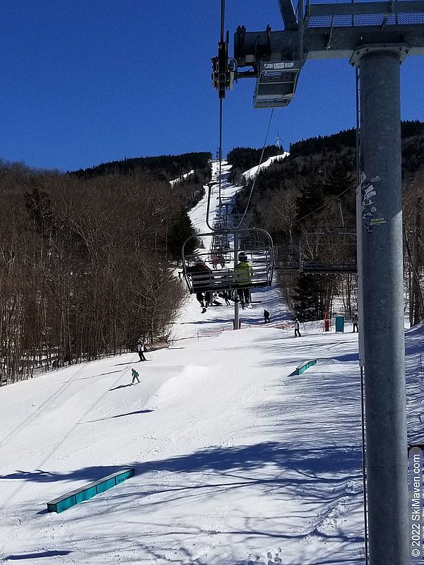 Photo taken while riding quad chairlift and looking down at skiers below