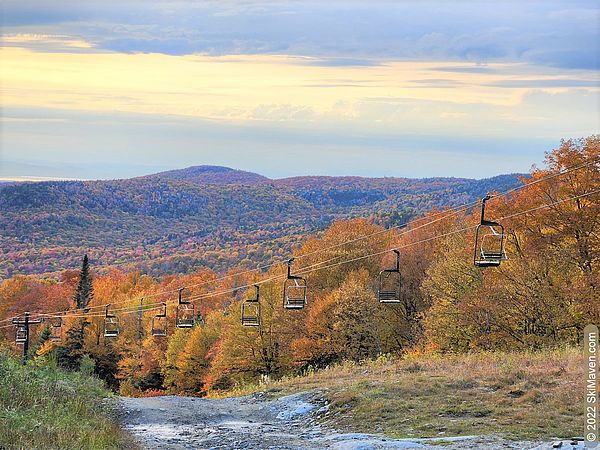 Orange fall foliage with a double chairlift in foreground