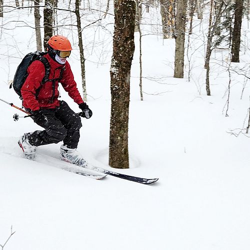 Telemark skier makes a tele turn in some fresh snow