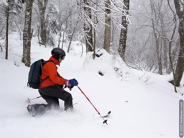 Photo of skier making a telemark turn and throwing snow