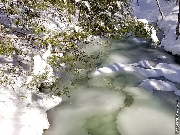 Snowy, icy river with water that looks greenish