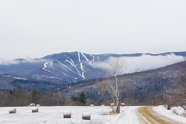 Farm and mountain view with a snowmaking cloud