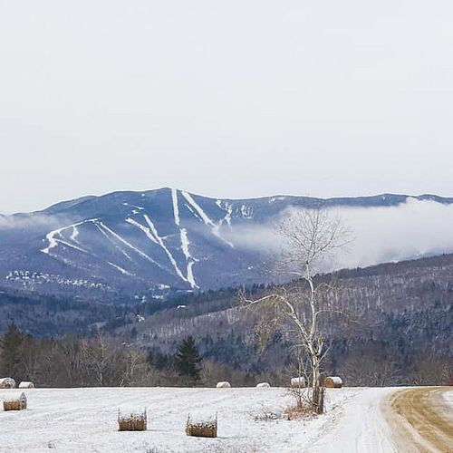 Farm and mountain view with a snowmaking cloud
