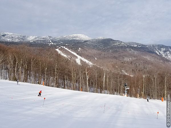 Photo of skiers with Mt. Mansfield in the background