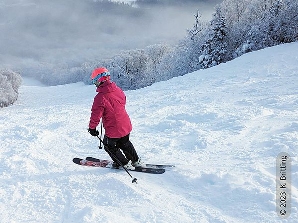 Skier makes a turn through broken powder