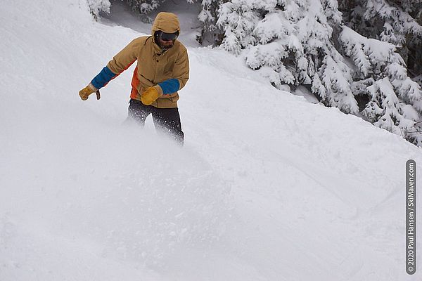 Photo of a snowboarder turning and throwing snow