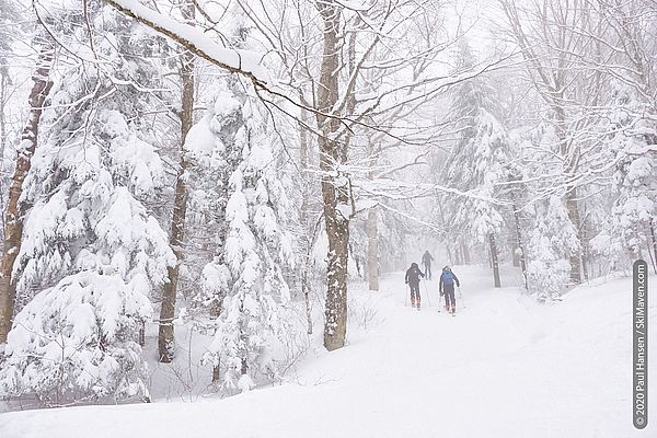 Photo of three skiers climbing a ski trail in fog