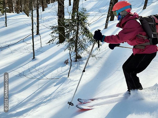 Skier with backpack descends in the woods