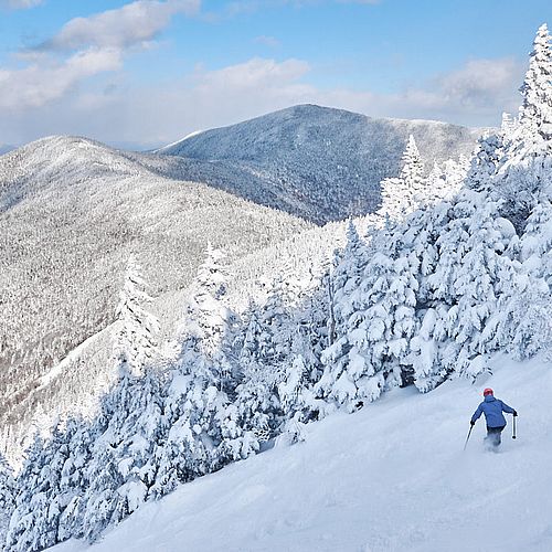 Photo of a skier on a snowy trail with a wintry view at Smugglers Notch, Vermont