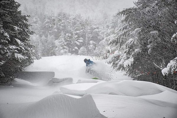 Photo of snowboarder cutting through a snowdrift