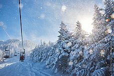 Discounts on lift tickets at Smugglers Notch, Vermont Photo of people riding chairlift on snowy day at Smugglers Notch, VErmont