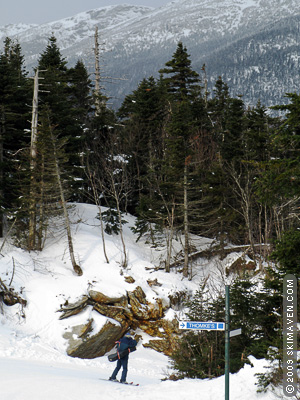 A pastor skis downhill with his guitar. A pastor skis downhill with his guitar.